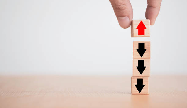 istock Hand putting up red arrow on wooden cube block on black arrow which opposite direction. Contrast different thinking and disruption concept. 1288099026