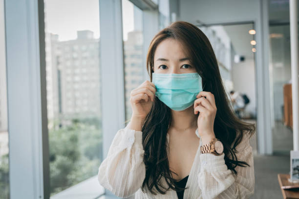 istock Asian woman wearing face mask indoors 1288100524