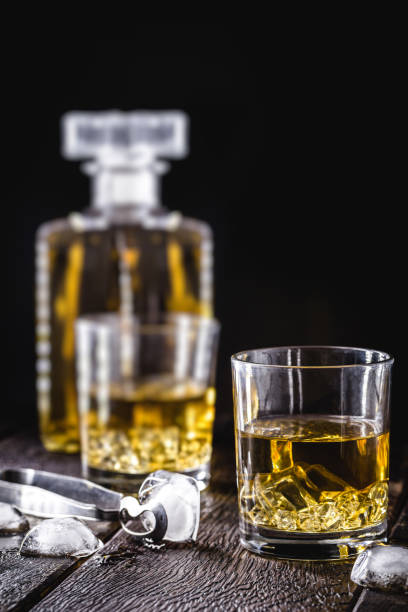 ウイスキーまたはバーボン、氷のガラスの中の麦芽と蒸留された飲み物、孤立した黒い背景に。 - whisky glass ice cube alcohol ストックフォトと画像