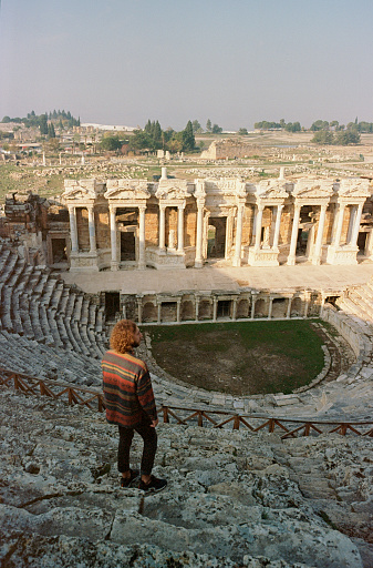 Young Caucasian man looking at ancient Rome theatre in Pamukkale