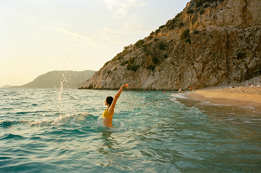 Young Caucasian woman swimming in the sea on Mediterranean coast in Turkey