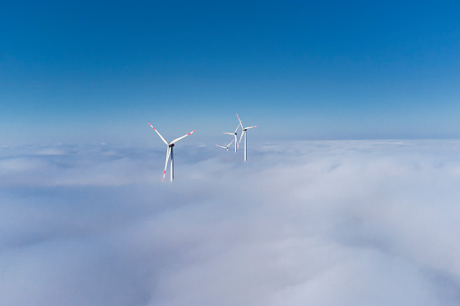 Wind turbines over the fog - aerial view