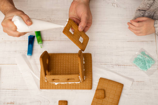 istock Dad and son are making a gingerbread house. Preparing for Christmas. 1288113596