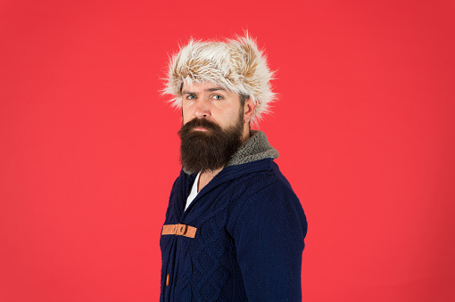 Posing for photo. bearded man ready for winter activity. get warm and comfortable. male fashion. serious trendy hipster. beard care in cold season. brutal man earflap hat. fur hat accessory.