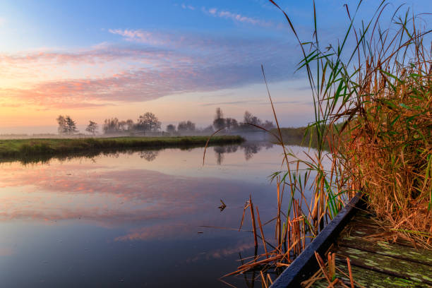 istock Dutch landscape at sunrise with canal in polder 1288114636