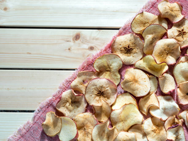 istock Top view of apple chips on a red towel illuminated by sunlight. With copy space. 1288117003