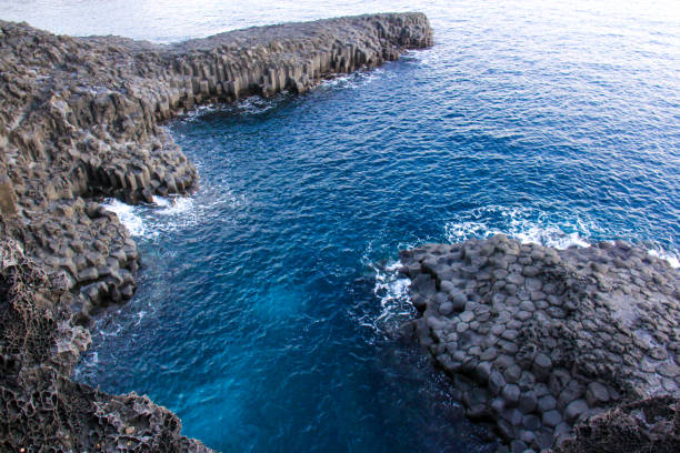 istock Rock cliff beach near the ocean, with clear blue water 1288117351