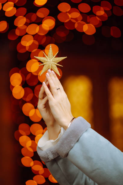 istock Woman's hands holding golden five pointed star decoration. 1288118569