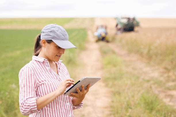 istock Smart farming. Woman using tablet to operate crop sprayer. Modernization in agriculture. 1288119079