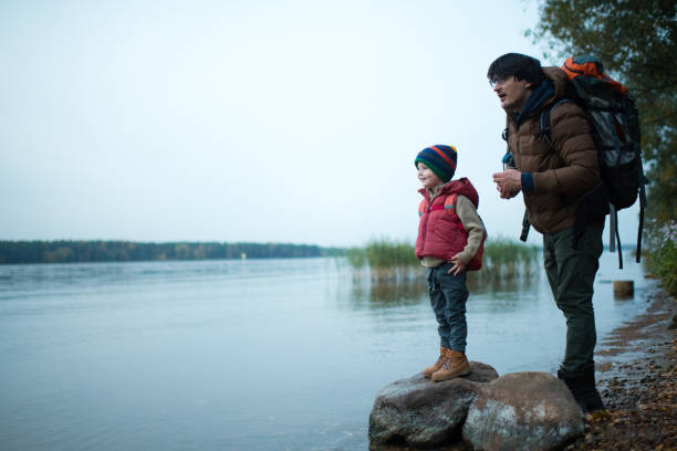 rodzina ciesząca się naturą - throwing stone little boys child zdjęcia i obrazy z banku zdjęć