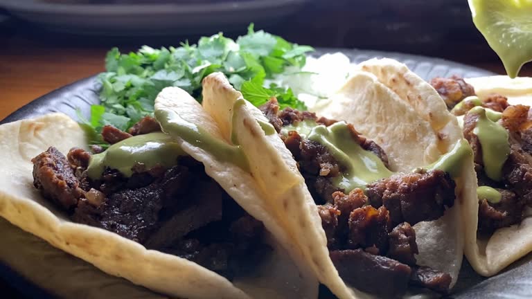 Pouring Salsa Over Carne Asada Street Tacos