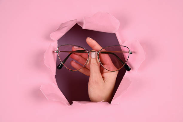 istock Hand holds glasses on a pink background 1288122014