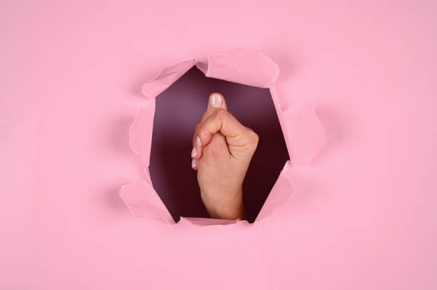 istock Female hand showing fig or thumb gesture on pink background 1288122817