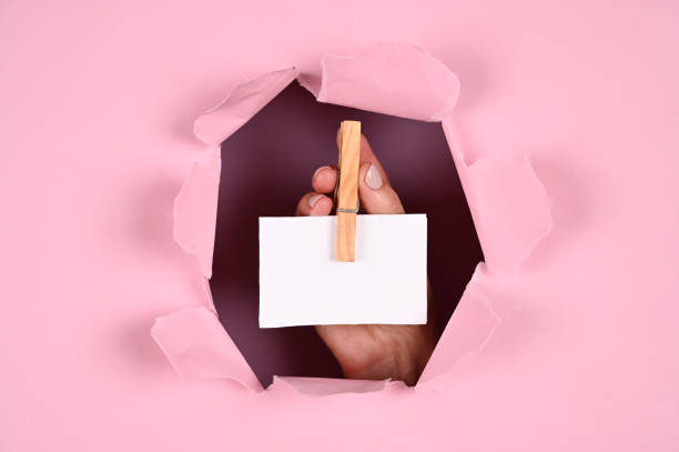 istock Hand holds a business card on a pink background 1288123087