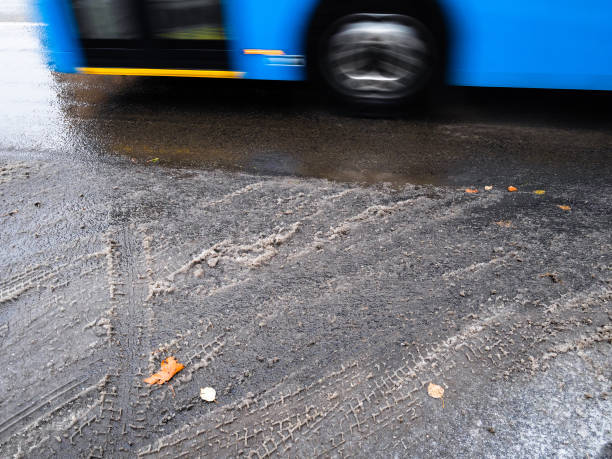 istock the first melted snow on city road and blue bus 1288124241