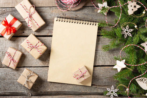 istock Christmas or new Year background with an open blank Notepad, spruce branches and Christmas ecofriendly wooden decorations. A checklist or a letter to Santa. Christmas business greeting card. Copyspace 1288124607
