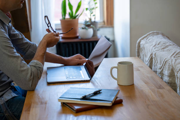 Man working from home at a table in is home office. stock photo