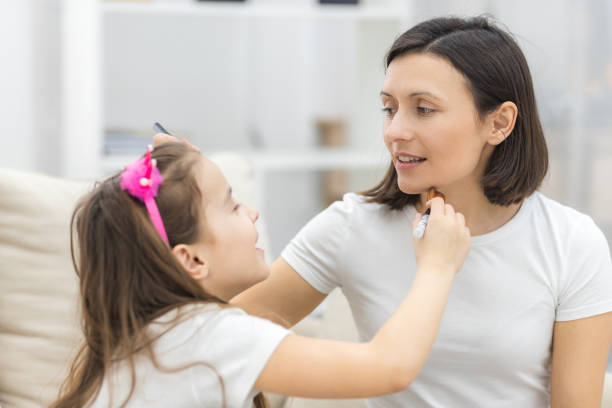 istock Pretty mother teaching her daughter doing make up at home. 1288127034
