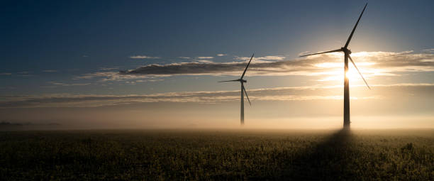 日の出時に2つの風力タービン - climate wind engine wind turbine ストックフォトと画像