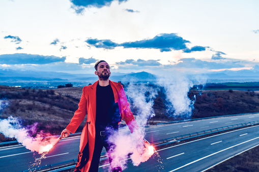 Male In Red Coat Battling Sunset With Fire Flares