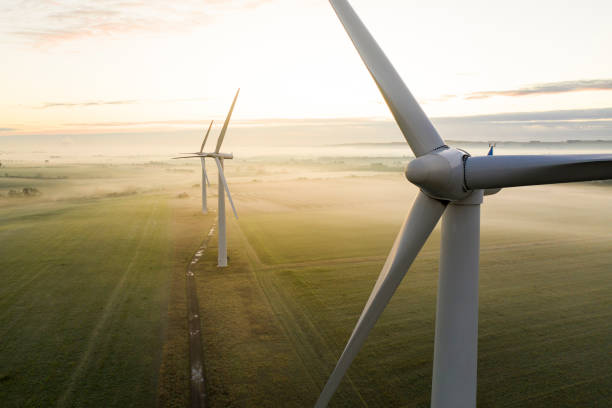 trois éoliennes au lever du soleil - climat photos et images de collection