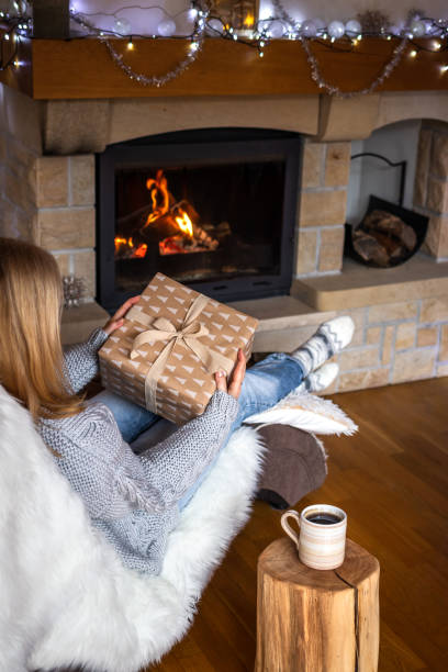istock Woman opening christmas present at home 1288131115