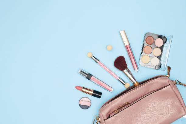 istock womens handbag with cosmetics, makeup tools and accessories on a blue background, beauty, fashion, shopping concept, flat lay 1288133204