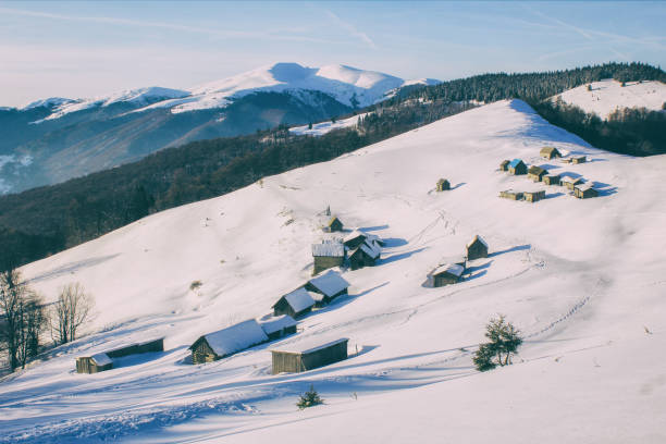 istock Winter landscape in a mountain valley with huts. Traditional alpine huts covered with a snow 1288134343