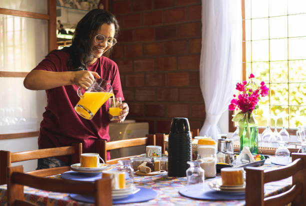 Woman serving orange juice in the kitchen