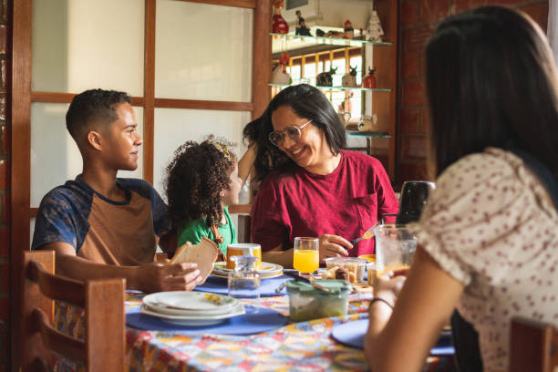 glückliche familie beim frühstück - breakfast eating people teens stock-fotos und bilder