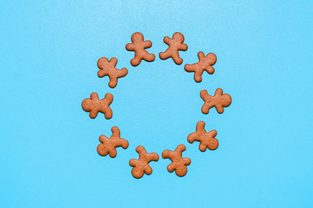 istock Gingerbread man cookies arranged in a circle on a blue background. 1288136910