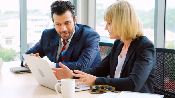 istock Two business people talk project strategy at office 1288137201