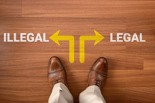 Businessman on laminate flooring and choose Illegal or Legal, two different ways