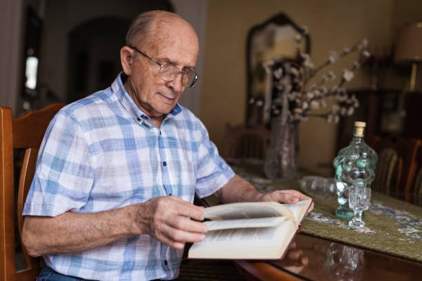 istock Senior man at home reading book 1288139458