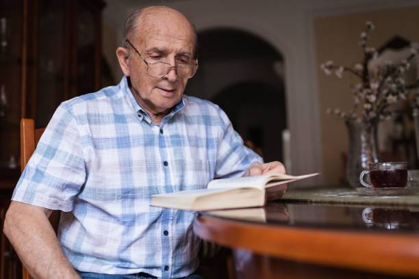 istock Senior man enjoying reading a book stock 1288139460