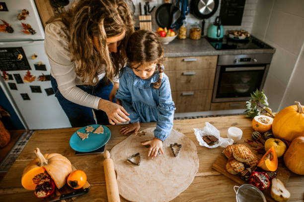 istock Little girl playing in kitchen, making cookies using cookie cutters 1288140405