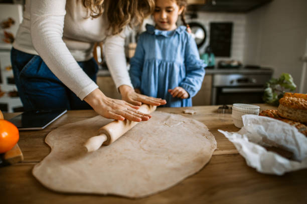 istock Mother and daughter kneading dough for biscuits for holiday celebration 1288140417