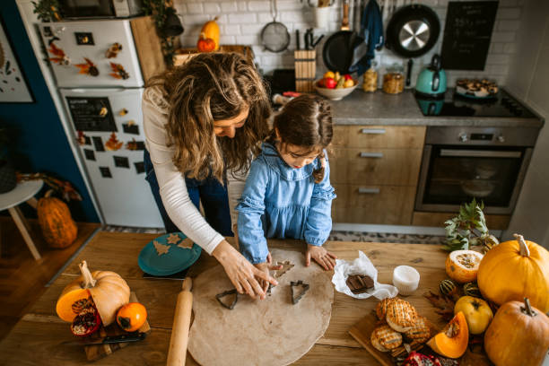 istock Little girl playing in kitchen, making cookies using cookie cutters 1288140458