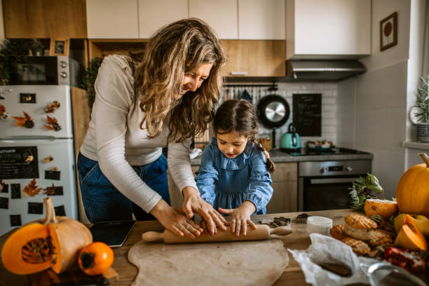 Mother and daughter kneading dough for biscuits for holiday celebration