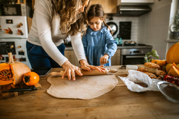 istock Mother and daughter kneading dough for biscuits for holiday celebration 1288140994