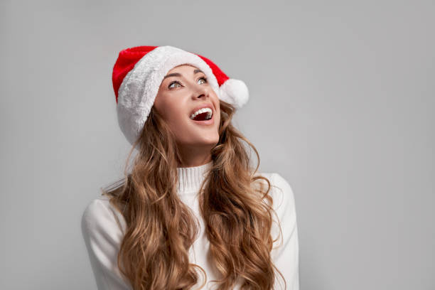 istock Woman christmas Sants Hat sweater white studio background 1288141000