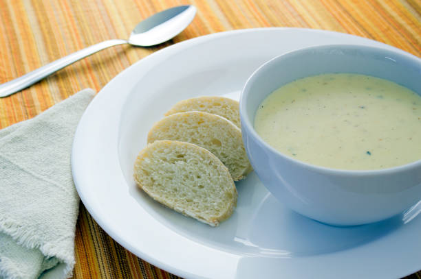 istock Cheese soup on a white bowl over a plate with sliced bread 1288142022