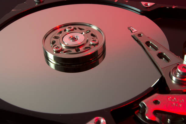 istock Hard drive internal metallic disks and mechanisms over red light 1288142110