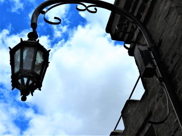 istock Medieval illuminated street lantern on a brick exterior wall. 1288143093