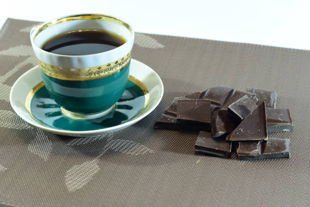 A cup of tea and pieces of chocolate.