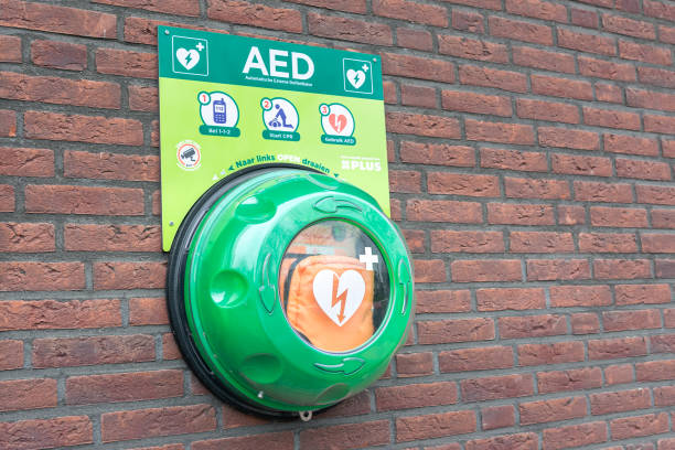 Automated external defibrillator on a wall Waddinxveen, Netherlands - November 2020: Automated external defibrillator (AED) on a brick wall. Portable electronic first aid device to restore heart rhythm. defibrillator photos stock pictures, royalty-free photos & images