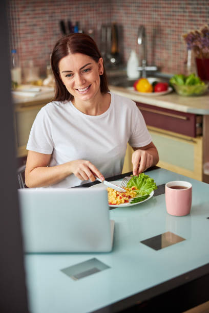 istock Female at the dinner table cutting her meal 1288148461