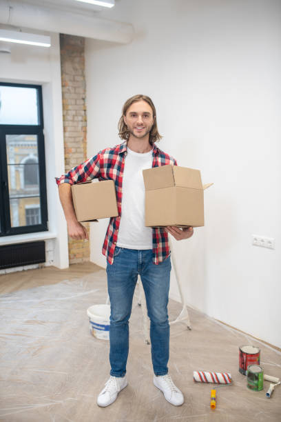 istock Fair-haired man standing near the wall with boxes in hands 1288148542
