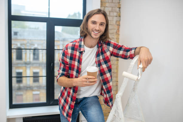 istock Young man standing near the stepladder and having cofee 1288148642