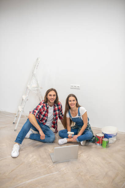 istock Young couple sitting on the floor and smiling 1288148780